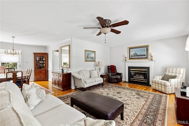 Living area with a chandelier, ceiling fan, a fire