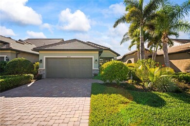 View of front of house with decorative driveway, an attached garage, stone siding, stucco siding, and a tile roof