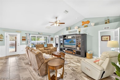 Living area featuring vaulted ceiling, a ceiling f