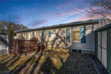 Back house at dusk with a shed and a wooden deck