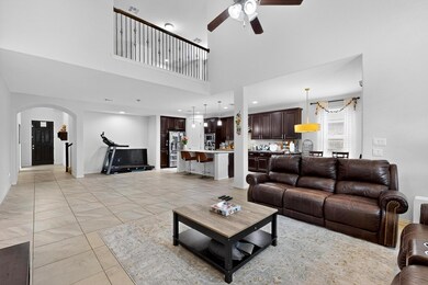 Living area with a ceiling fan, arched walkways, 