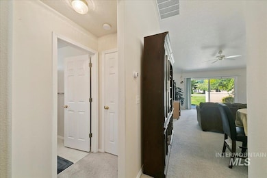 Hall featuring a textured ceiling and light carpet