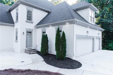 View of front of home featuring roof with shingles, stucco siding, an attached garage, and concrete driveway