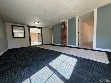 Carpeted spare room with a textured ceiling