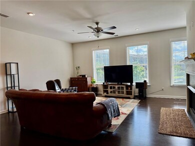 Living room featuring a ceiling fan, a fireplace, dark wood finished floors, and recessed lighting
