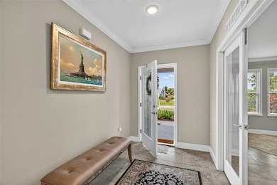 Entryway featuring ornamental molding, french doors, plenty of natural light, and a textured ceiling