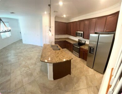 Kitchen featuring light stone counters, crown mold