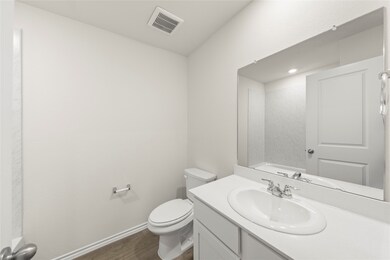 Full bath with vanity and dark wood-style flooring