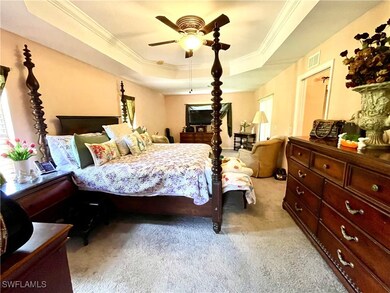 Bedroom with visible vents, light carpet, crown mo