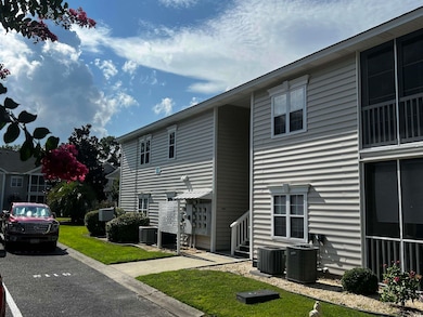 View of building exterior featuring uncovered parking