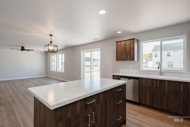 Kitchen with light wood-style floors, a center island, healthy amount of natural light, and recessed lighting