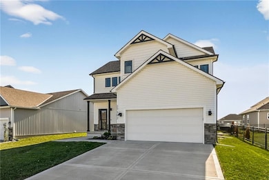 View of front of home with stone siding, driveway, an attached garage, and a shingled roof