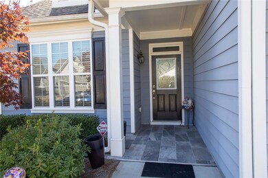 Doorway to property with a porch and a shingled roof
