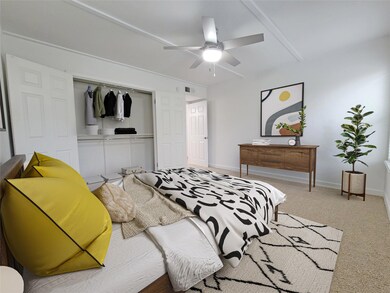 Carpeted bedroom featuring ceiling fan and a close