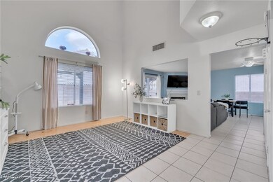 Foyer featuring a towering ceiling, healthy amount of natural light, and light tile patterned floors