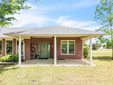 Back of property featuring a yard, brick siding, a