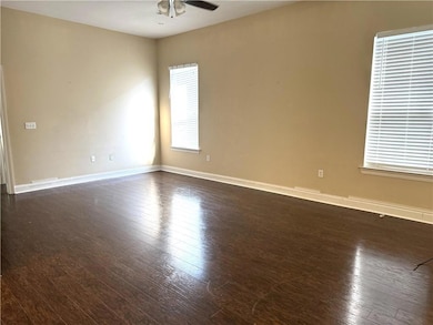 Spacious living area with high ceilings and pretty wood floors.