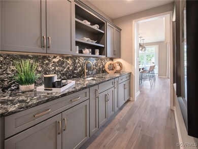 Bar featuring sink, gray cabinets, dark stone coun