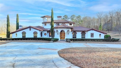 View of front of property featuring stucco siding, curved driveway, and a tiled roof
