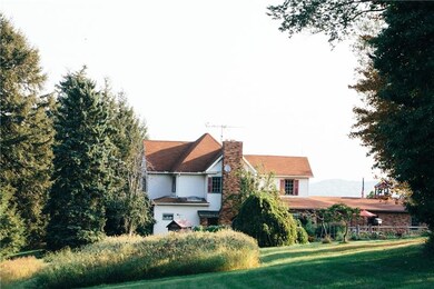 Mature trees and fields border the historic home.