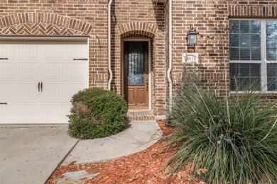 Heavy wood door with glass and wrought iron greets