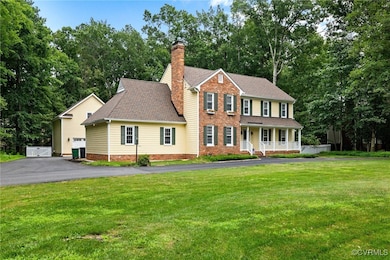 Colonial home with a porch, a chimney, roof with s