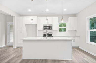 Kitchen featuring appliances with stainless steel finishes, light countertops, white cabinets, tasteful backsplash, and recessed lighting