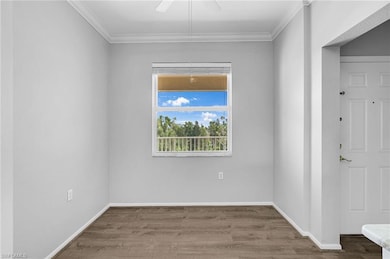 Unfurnished room featuring crown molding, wood fin