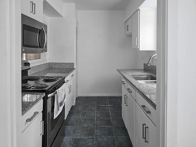 Kitchen featuring a sink, dark stone countertops, 