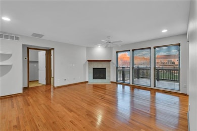 Unfurnished living room with recessed lighting, light wood-style flooring, a tiled fireplace, and a ceiling fan