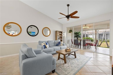 Tiled living area with baseboards, a ceiling fan, 