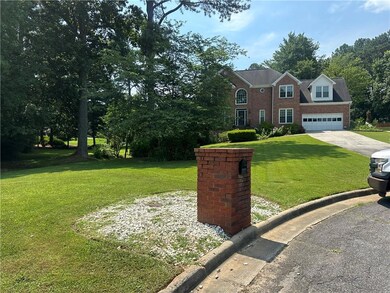 View of front of property featuring driveway, a front lawn, and brick siding