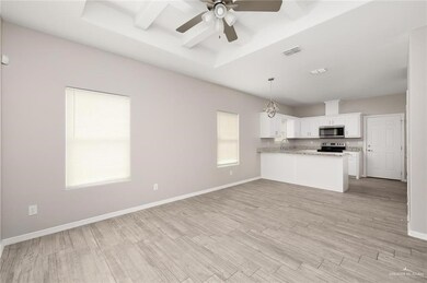 Kitchen with stainless steel appliances, ceiling fan, a peninsula, light wood-style flooring, and white cabinets