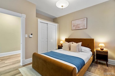 Bedroom with light wood-style floors and a closet