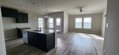 Kitchen featuring light stone counters, ceiling fa
