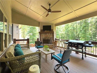 Wooden terrace featuring an outdoor living space with a fireplace, grilling area, and ceiling fan