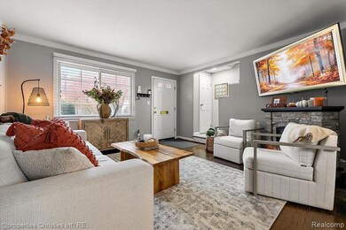 Living area featuring crown molding, wood finished floors, and a fireplace