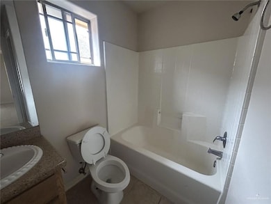 Bathroom with tile patterned floors, toilet, vanity, tub / shower combination, and baseboards