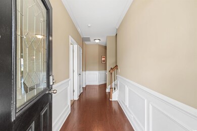 Corridor featuring crown molding and dark hardwood