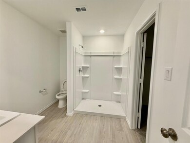 Bathroom with a shower, hardwood / wood-style floors, vanity, and toilet