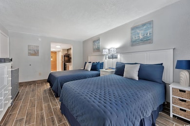 Bedroom featuring black refrigerator, connected ba