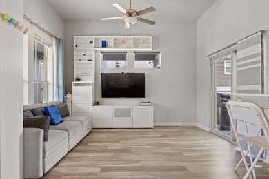 Living room with a ceiling fan, light wood-style 