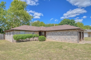 Ranch-style home featuring a garage and a front lawn