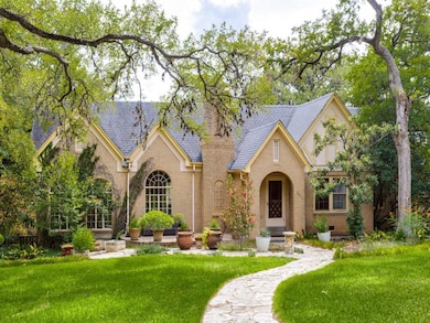 Tudor home featuring brick siding, a front yard, 
