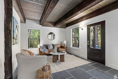Living area with beamed ceiling and tile patterned flooring