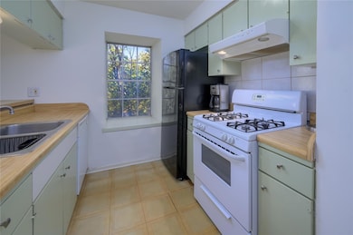 Kitchen with white appliances, light countertops,
