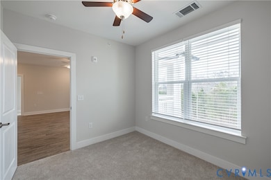 Spare room with light carpet and ceiling fan