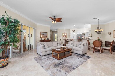 Living room with ceiling fan with notable chandelier and crown molding
