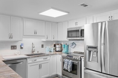 Kitchen with stainless steel appliances, a sink, w