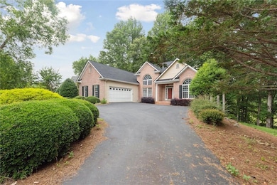 Ranch-style house with asphalt driveway, brick siding, and a garage